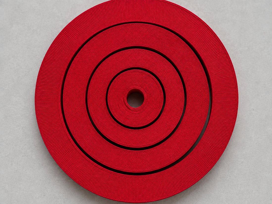 Four widths of red grosgrain ribbon coiled one inside the other