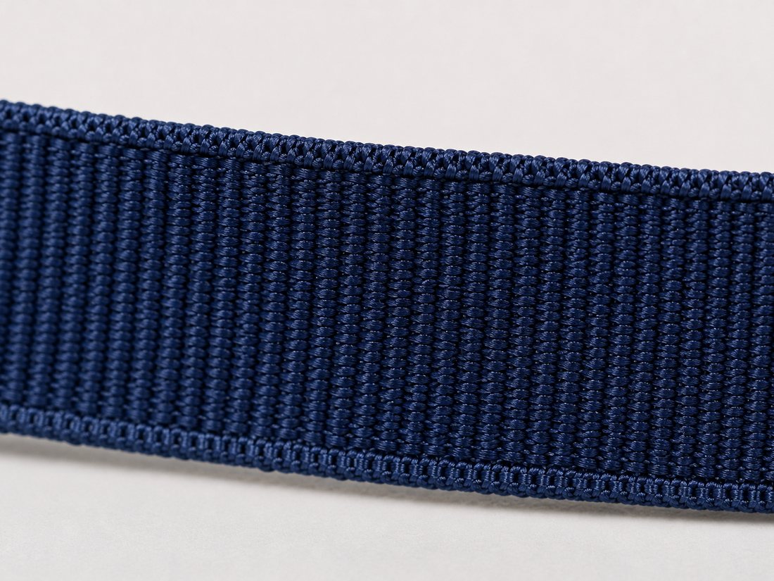 Macro of the woven edge along a navy grosgrain ribbon