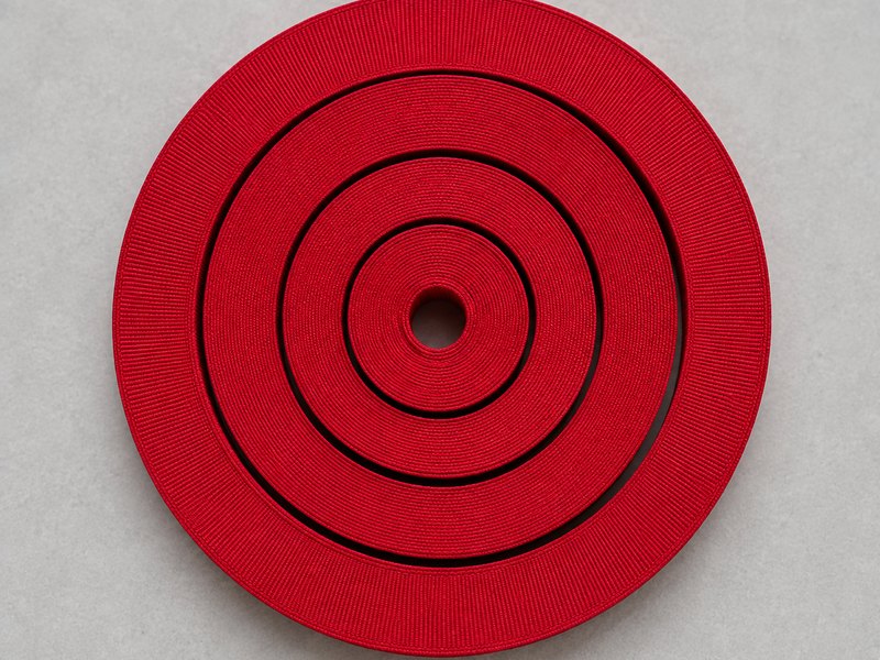 Four widths of red grosgrain ribbon coiled one inside the other